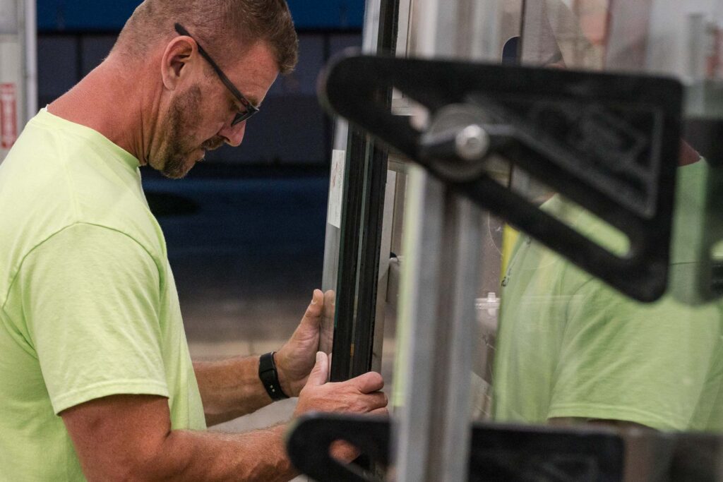 McIntyre Glass technician repairing commercial door hardware on an aluminum entrance